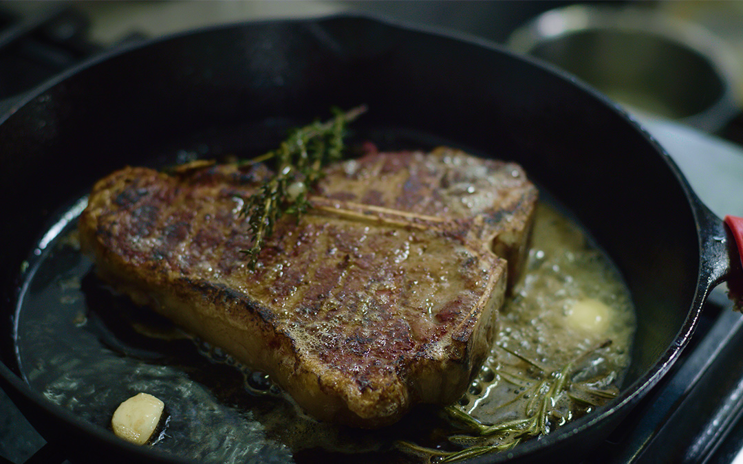 African Spice-Rubbed Porterhouse with Curried Shrimp Pearl Pasta & Collard Green Chimichurri