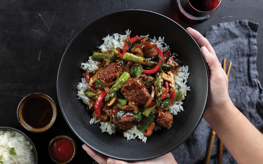 Filet mignon crispy steak stir fry served on a bed of rice in a bowl