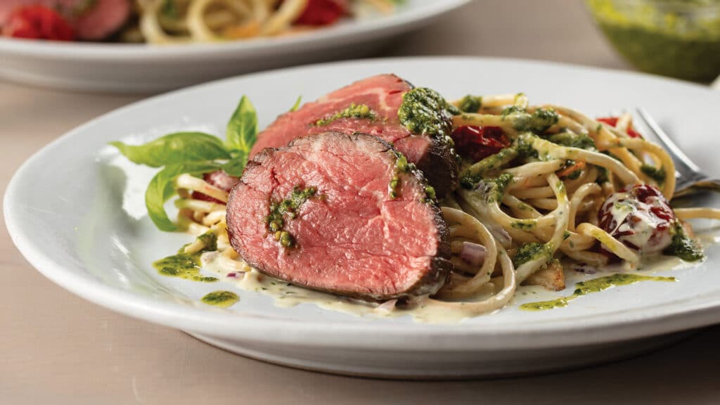 Spinach-Pesto Stuffed Chateaubriand with Broken Spaghetti on a white plate